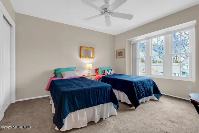 a bedroom with two beds and a large window