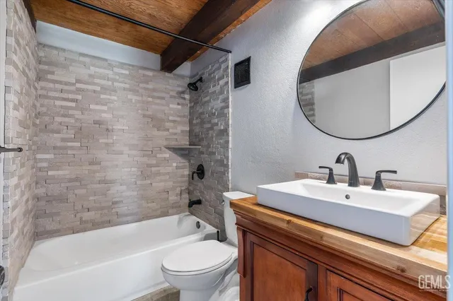 a bathroom with a sink mirror toilet and bathtub