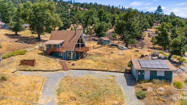 an aerial view of a house with a yard covered with snow in the background