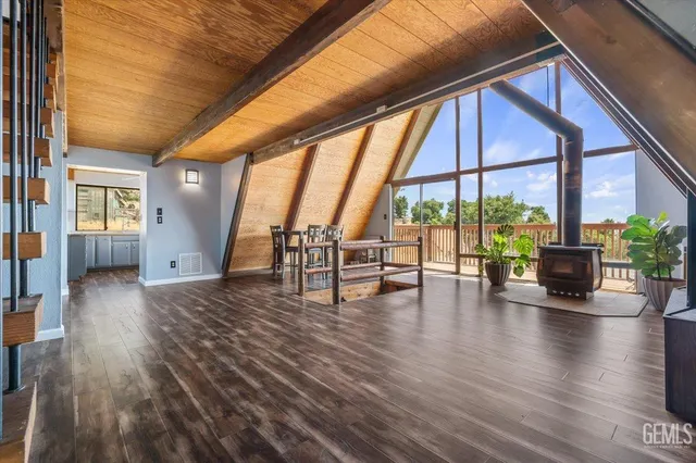 a view of empty room with wooden floor and floor to ceiling windows