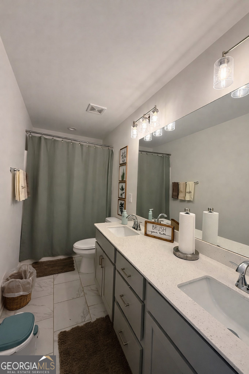 4355 Cornwall Drive Forsyth, GA 31029 - Photo 18 of 23 a bathroom with a double vanity sink and a mirror