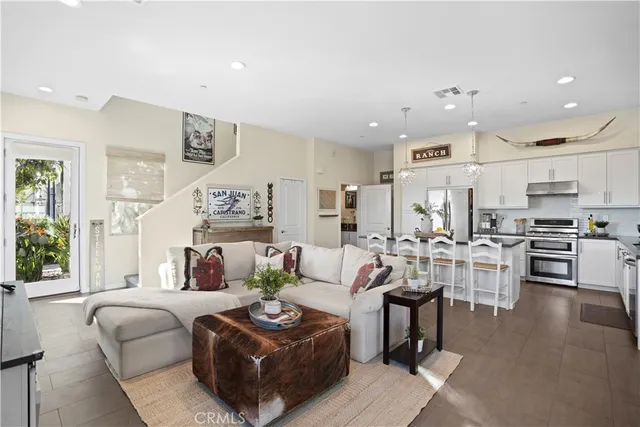 a living room with furniture a flat screen tv and a window