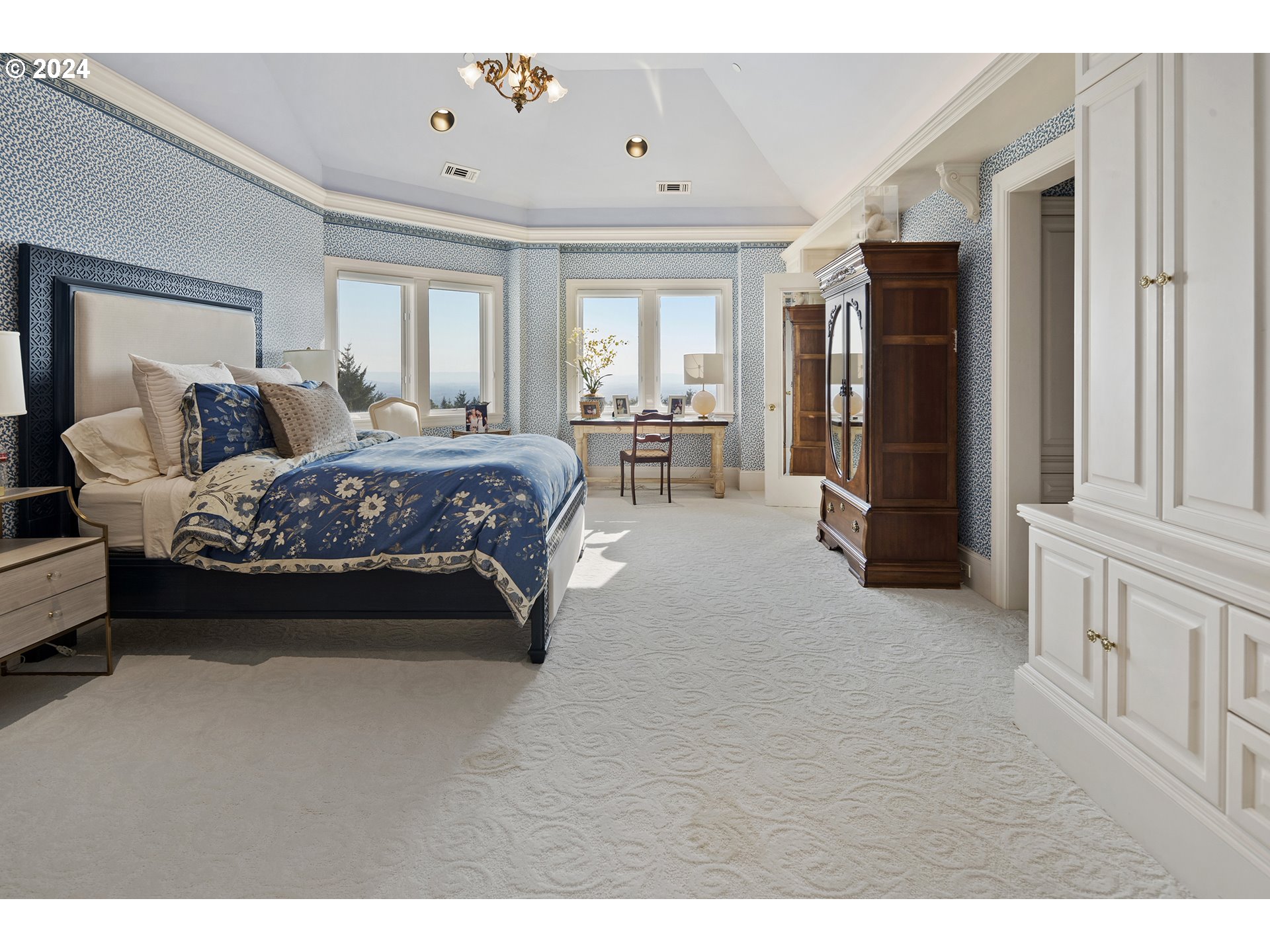 11223 Northwest Saltzman Road Portland, OR 97229 - Photo 32 of 46 a spacious bedroom with a bed a table and large mirror