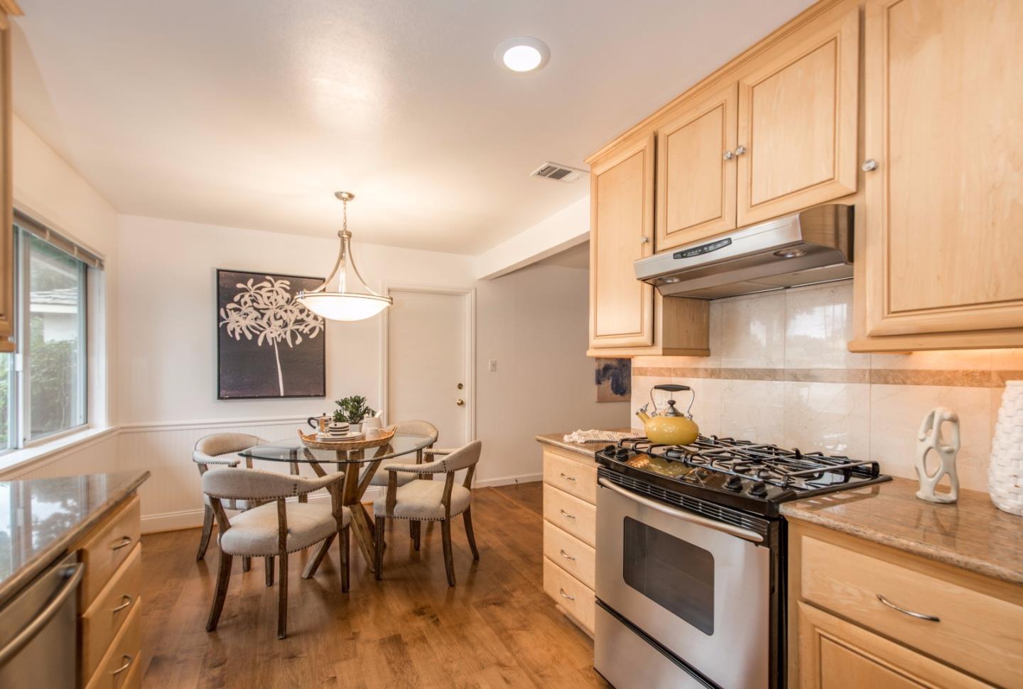 1003 Mango Avenue Sunnyvale, CA 94087 - Photo 7 of 23 a kitchen with stainless steel appliances a stove a sink dishwasher and a dining table with cabinets