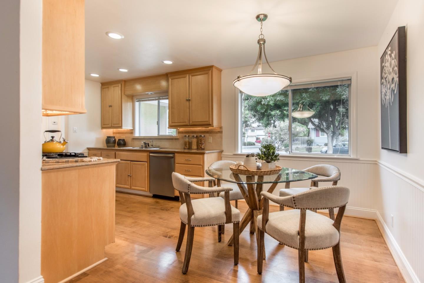 1003 Mango Avenue Sunnyvale, CA 94087 - Photo 9 of 23 a dining room with stainless steel appliances kitchen island granite countertop a sink a stove a dining table and chairs