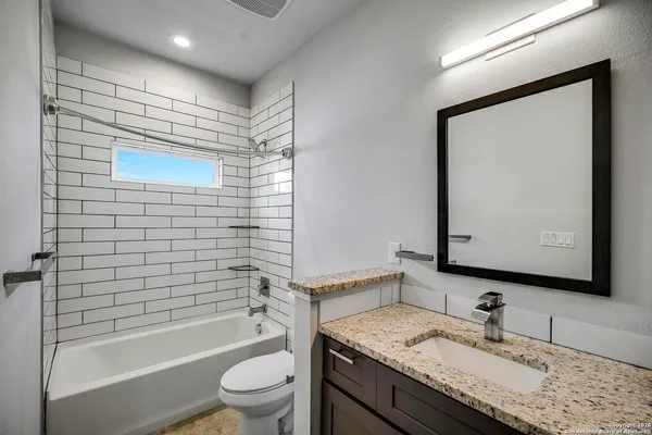 a bathroom with a granite countertop sink toilet and shower