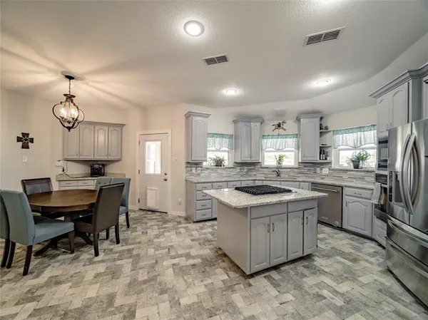 a kitchen with kitchen island a sink stove and refrigerator