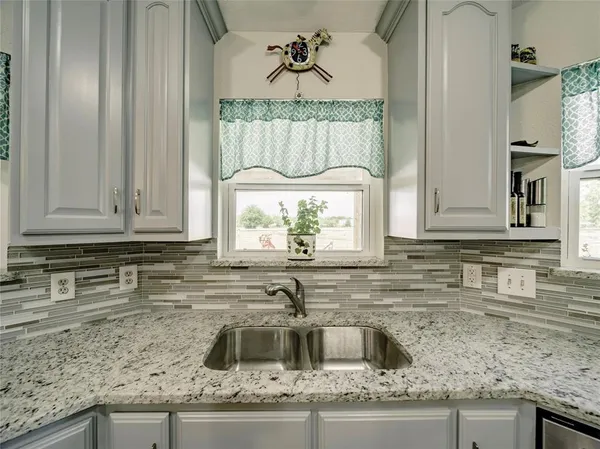 a kitchen with granite countertop a sink and a stove