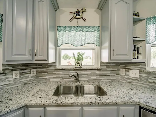 a kitchen with granite countertop a sink and a stove