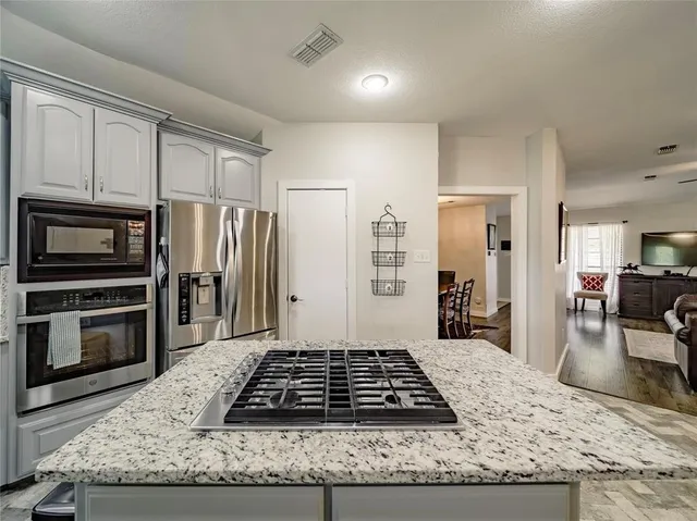 a kitchen with granite countertop a stove and a refrigerator