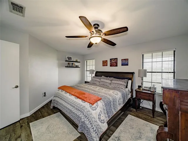 a bed room with a bed and a ceiling fan