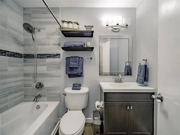 a bathroom with a sink toilet a mirror and bathtub