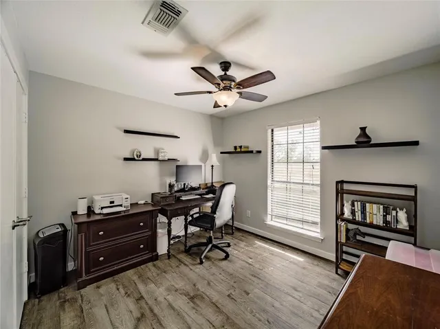 a view of a workspace with furniture and a window