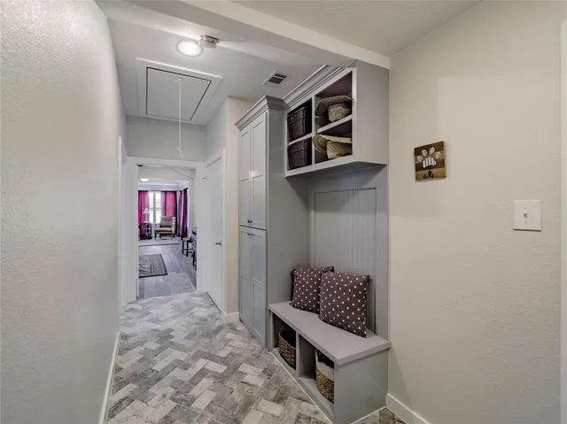 a hallway with a white cabinets and wooden floor