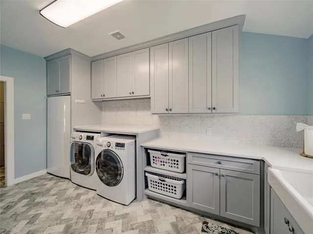 a utility room with sink dryer and washer