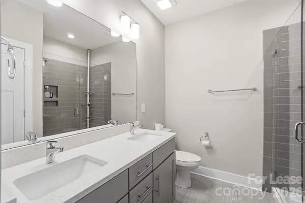 a bathroom with a double vanity sink toilet and shower
