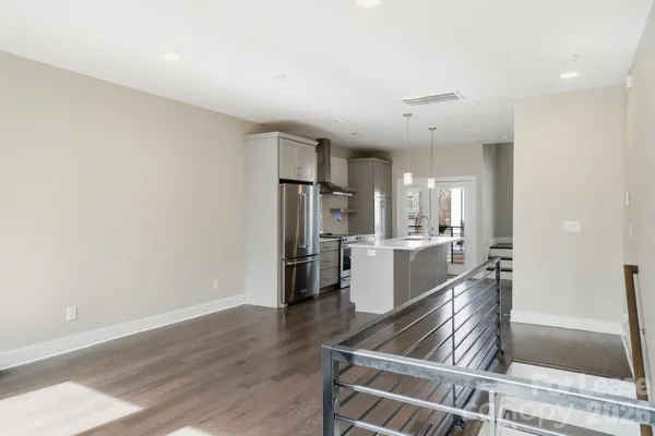a kitchen with a refrigerator and wooden floor