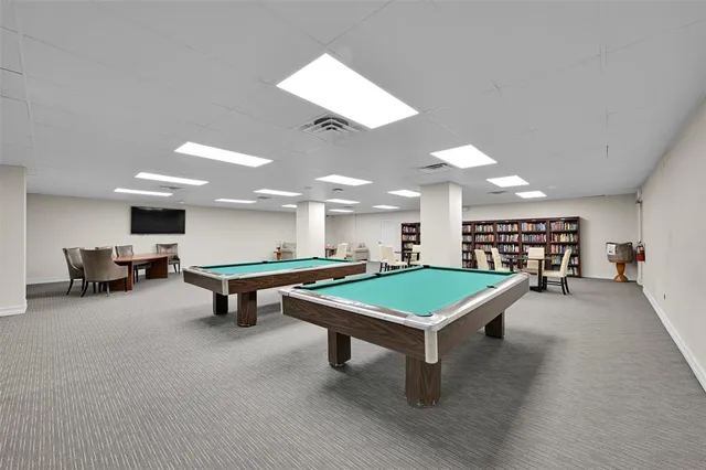 a room with pool table and windows