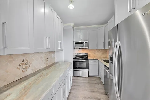 a kitchen with stainless steel appliances granite countertop a refrigerator sink and stove