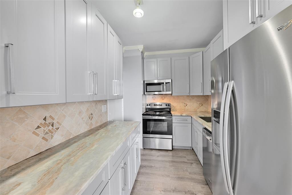 5005 Collins Avenue, Unit PH6 Miami Beach, FL 33140 - Photo 7 of 34 a kitchen with stainless steel appliances granite countertop a refrigerator sink and stove
