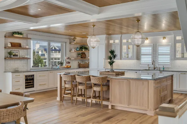 a view of a dining room with furniture a kitchen and chandelier