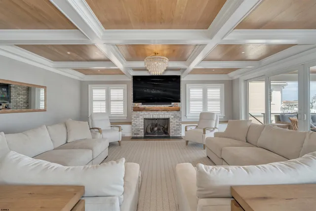 a view of a dining room with furniture a kitchen and chandelier