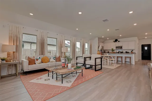 a living room with furniture and kitchen view