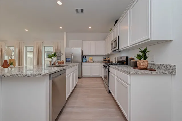a kitchen with stainless steel appliances granite countertop lots of counter top space and cabinets