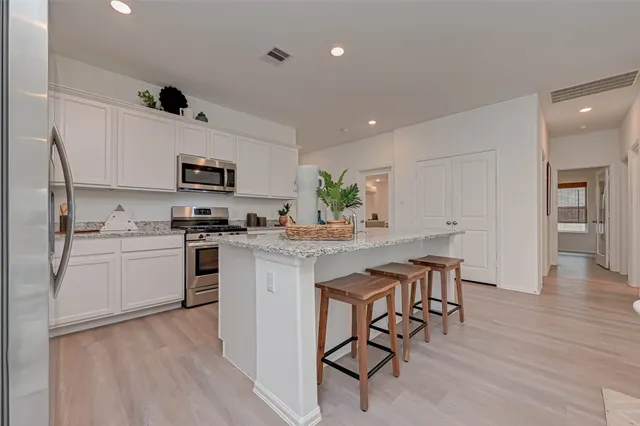 a kitchen with white cabinets and appliances
