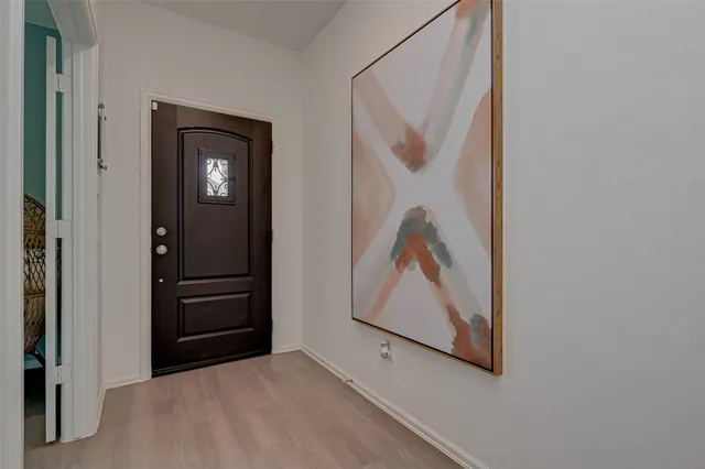 a view of a hallway with wooden floor and closet