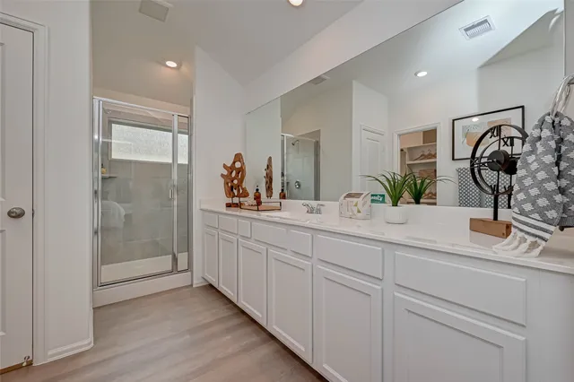 a bathroom with double vanity sink and a mirror
