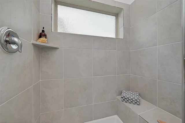 a bathroom with a window and a shower