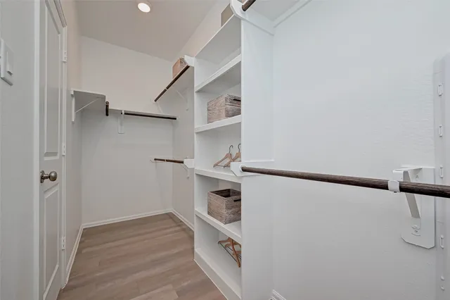 a view of walk in closet with empty racks