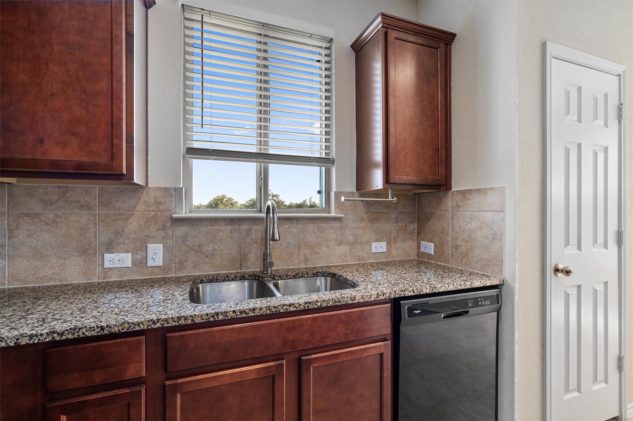 146 Russet Trail Georgetown, TX 78628 - Photo 12 of 37 a kitchen with granite countertop a sink a window and cabinets