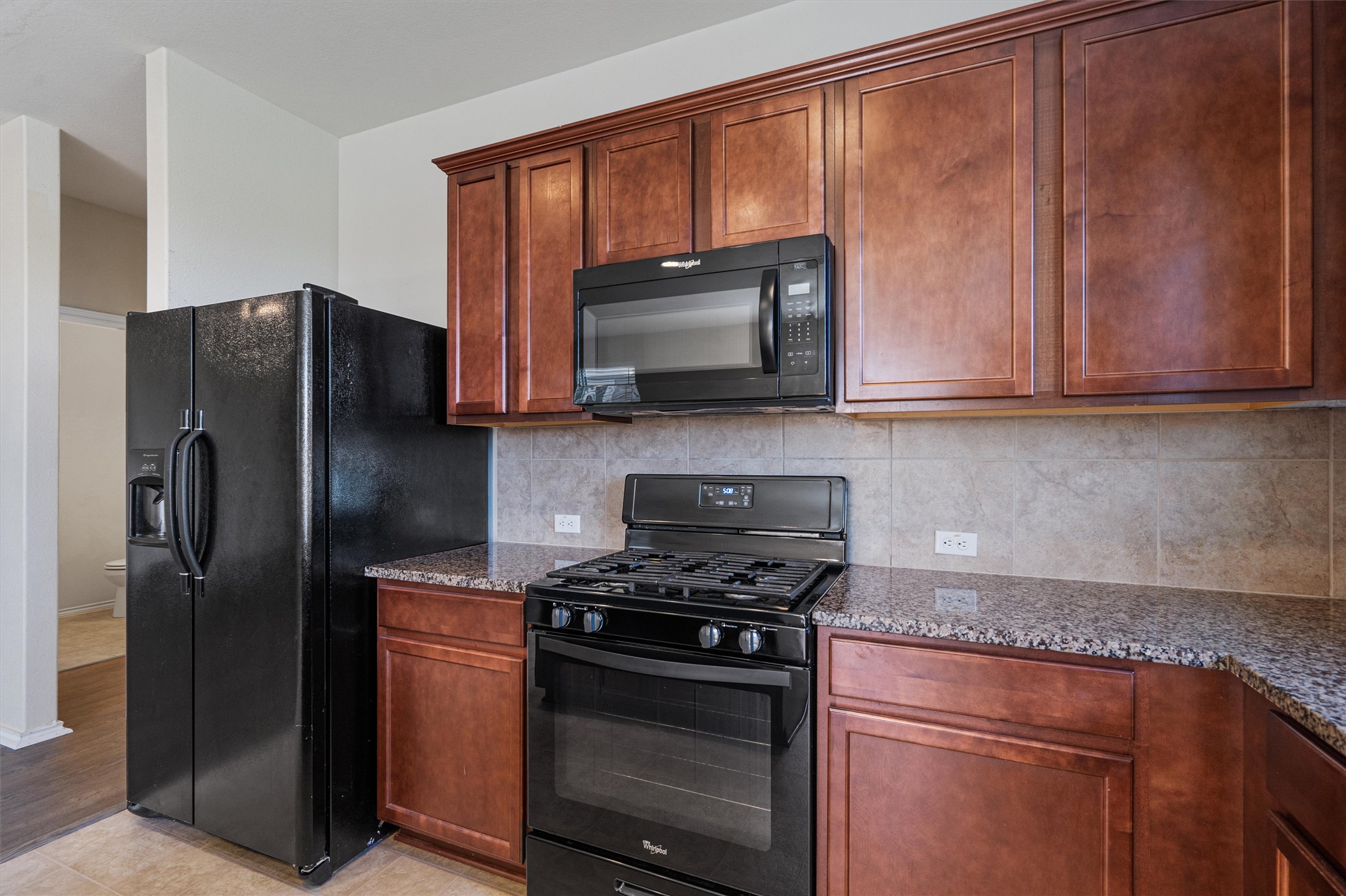 146 Russet Trail Georgetown, TX 78628 - Photo 13 of 37 a kitchen with granite countertop wooden cabinets and stainless steel appliances