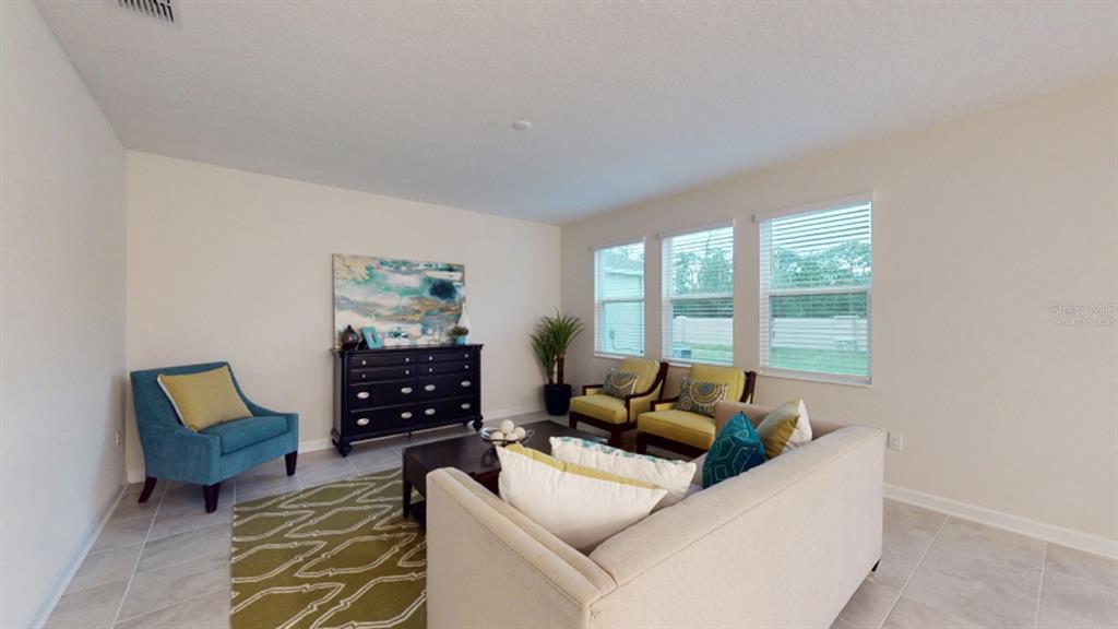 5608 Lemon Grass Street Clermont, FL 34714 - Photo 6 of 19 a living room with furniture and a floor to ceiling window