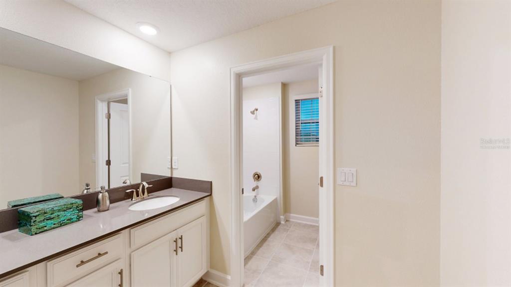5608 Lemon Grass Street Clermont, FL 34714 - Photo 7 of 19 a spacious bathroom with a granite countertop sink and a mirror