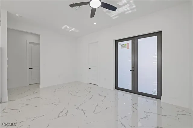 a view of an empty room with a ceiling fan and window