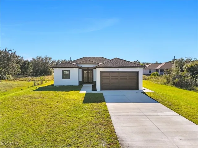 a view of house with swimming pool and a yard