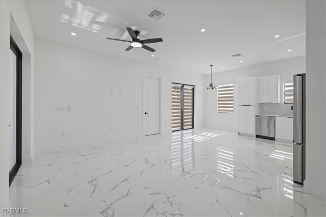 a view of empty room with wooden floor and windows