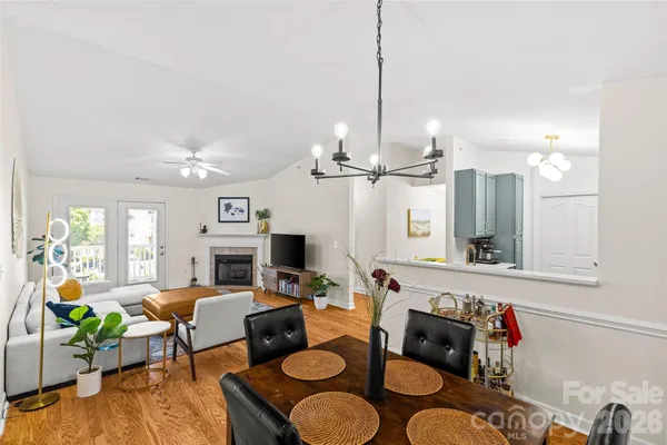 a living room with furniture kitchen view and a chandelier