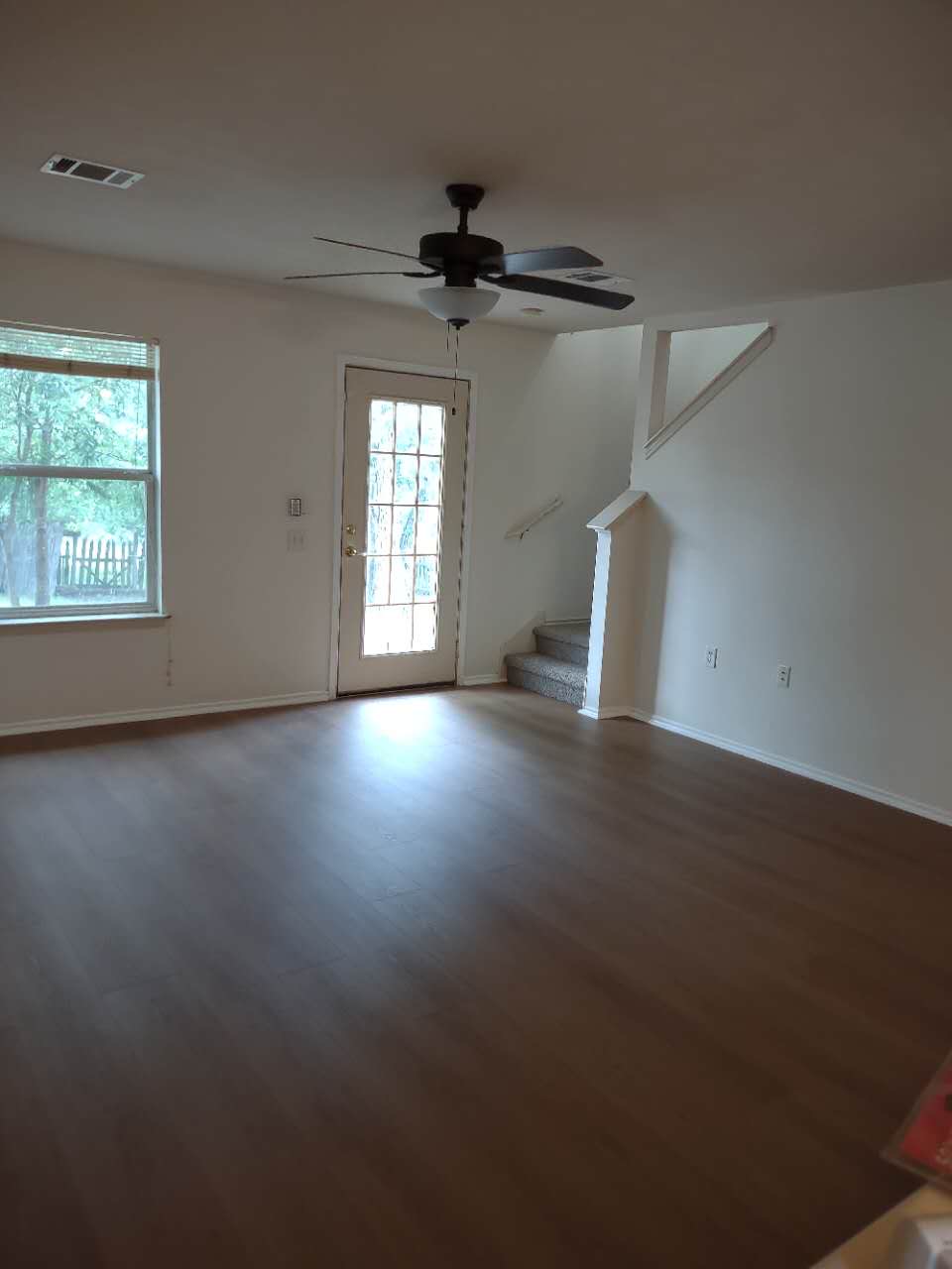 11709 Briarcreek Loop Manor, TX 78653 - Photo 2 of 19 Hardwood-style flooring extends across this spacious living area with a ceiling fan and backyard access.