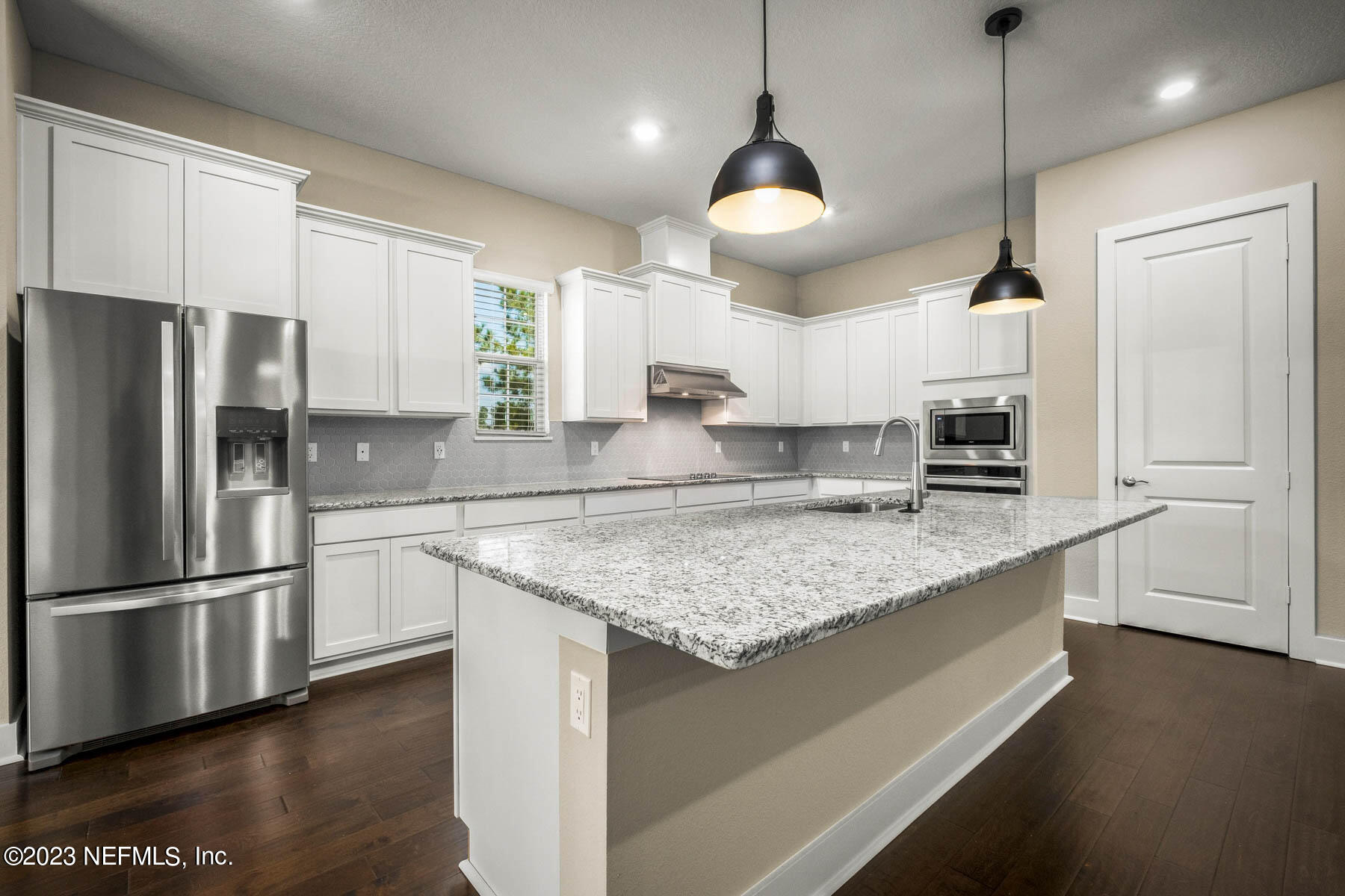 36426 Pitch Lane Hilliard, FL 32046 - Photo 6 of 14 a kitchen with stainless steel appliances granite countertop a sink a refrigerator a center island a stove and wooden floors