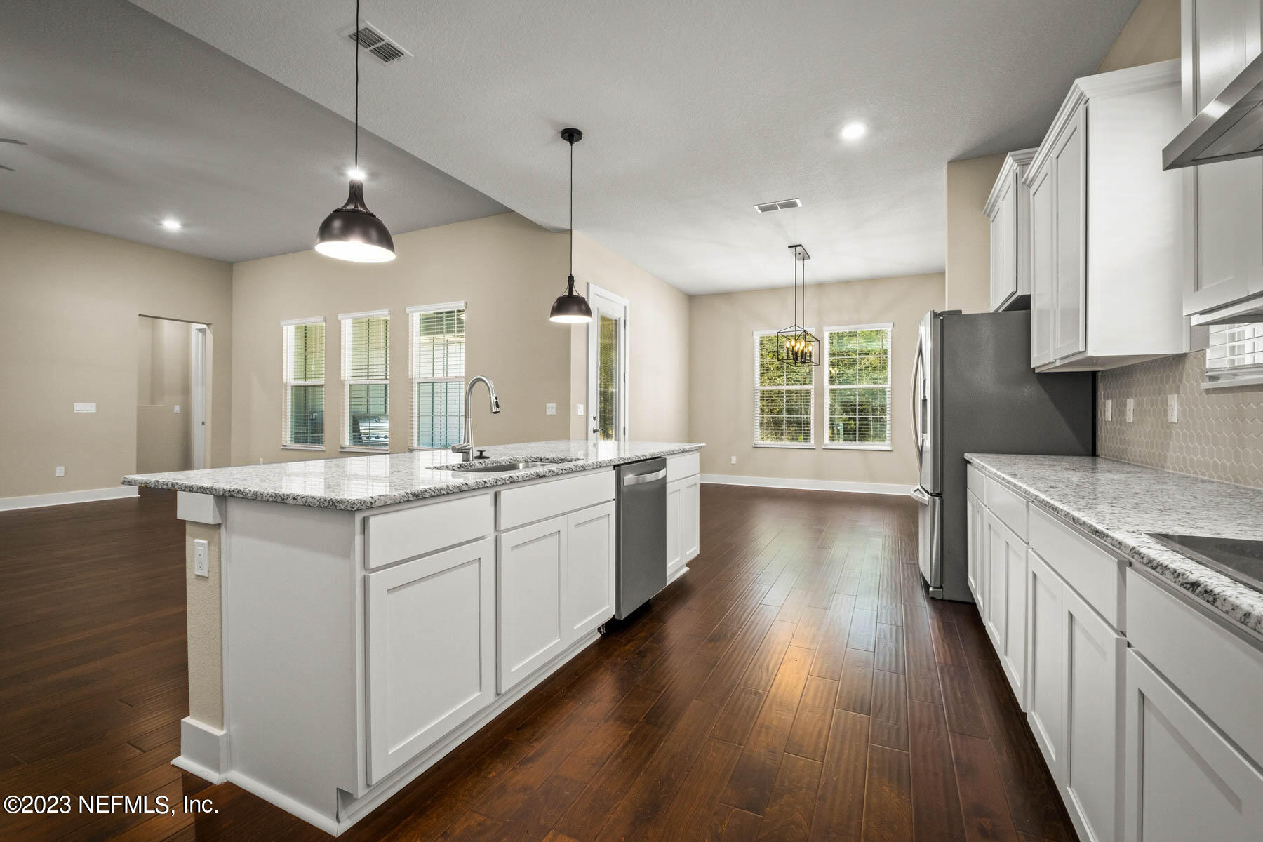 36426 Pitch Lane Hilliard, FL 32046 - Photo 7 of 14 a large kitchen with granite countertop a large counter top a sink stainless steel appliances and cabinets