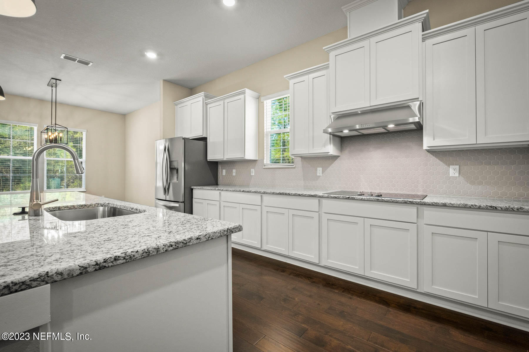 36426 Pitch Lane Hilliard, FL 32046 - Photo 8 of 14 a kitchen with stainless steel appliances granite countertop a sink a stove and white cabinets