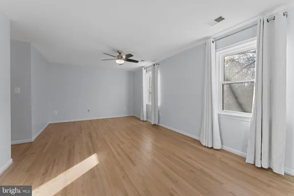 a view of an empty room with wooden floor