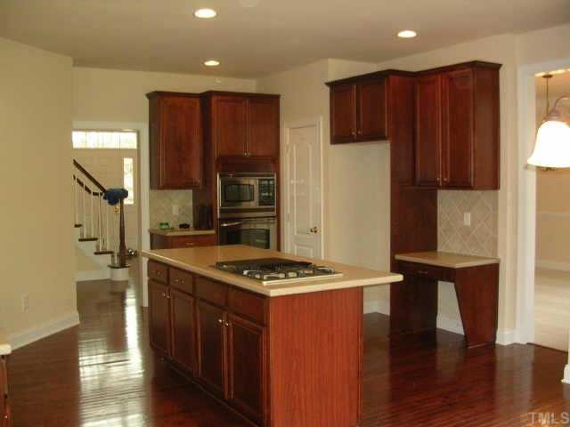 11726 Broadfield Court Raleigh, NC 27617 - Photo 5 of 6 a kitchen with stainless steel appliances granite countertop a stove a refrigerator and a wooden cabinets