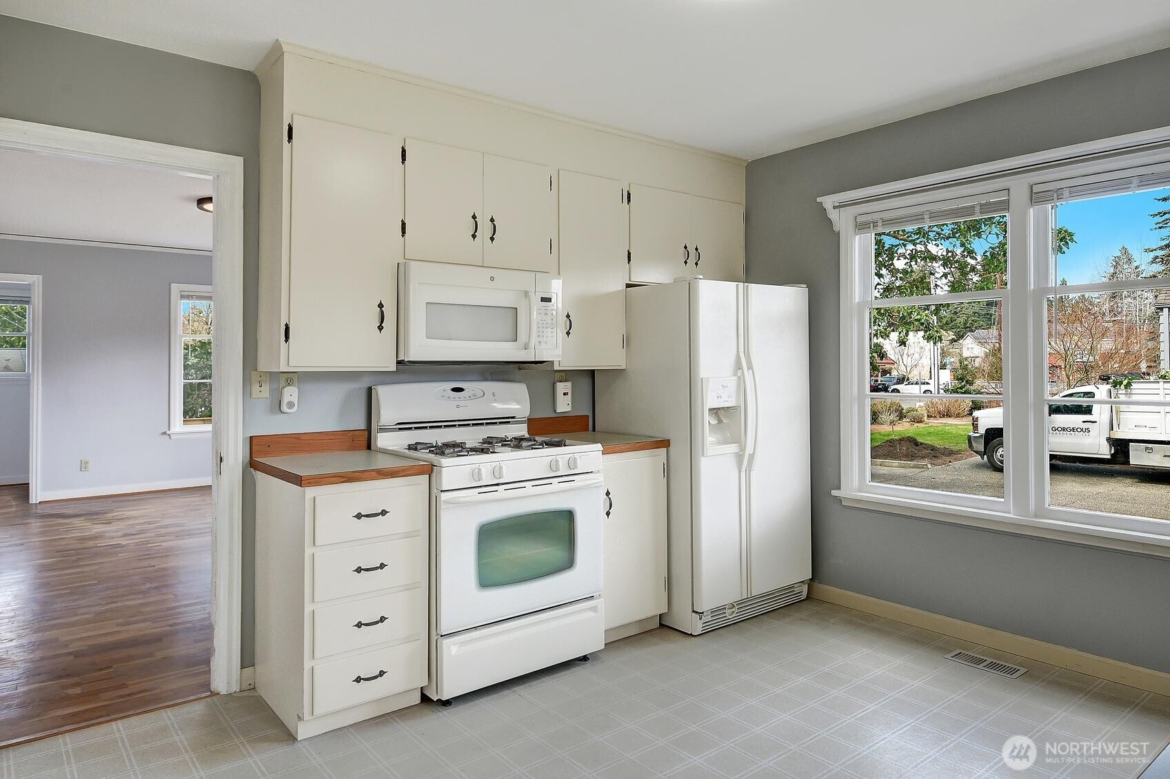 19330 20th Avenue Northwest Shoreline, WA 98177 - Photo 6 of 18 a kitchen with stainless steel appliances white cabinets and wooden floors