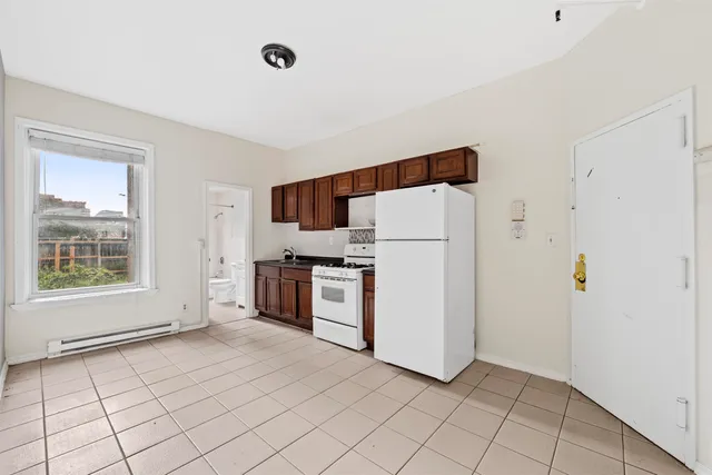 a view of kitchen with cabinets and refrigerator