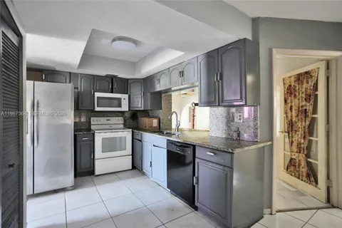 a kitchen with stainless steel appliances granite countertop a refrigerator and a stove